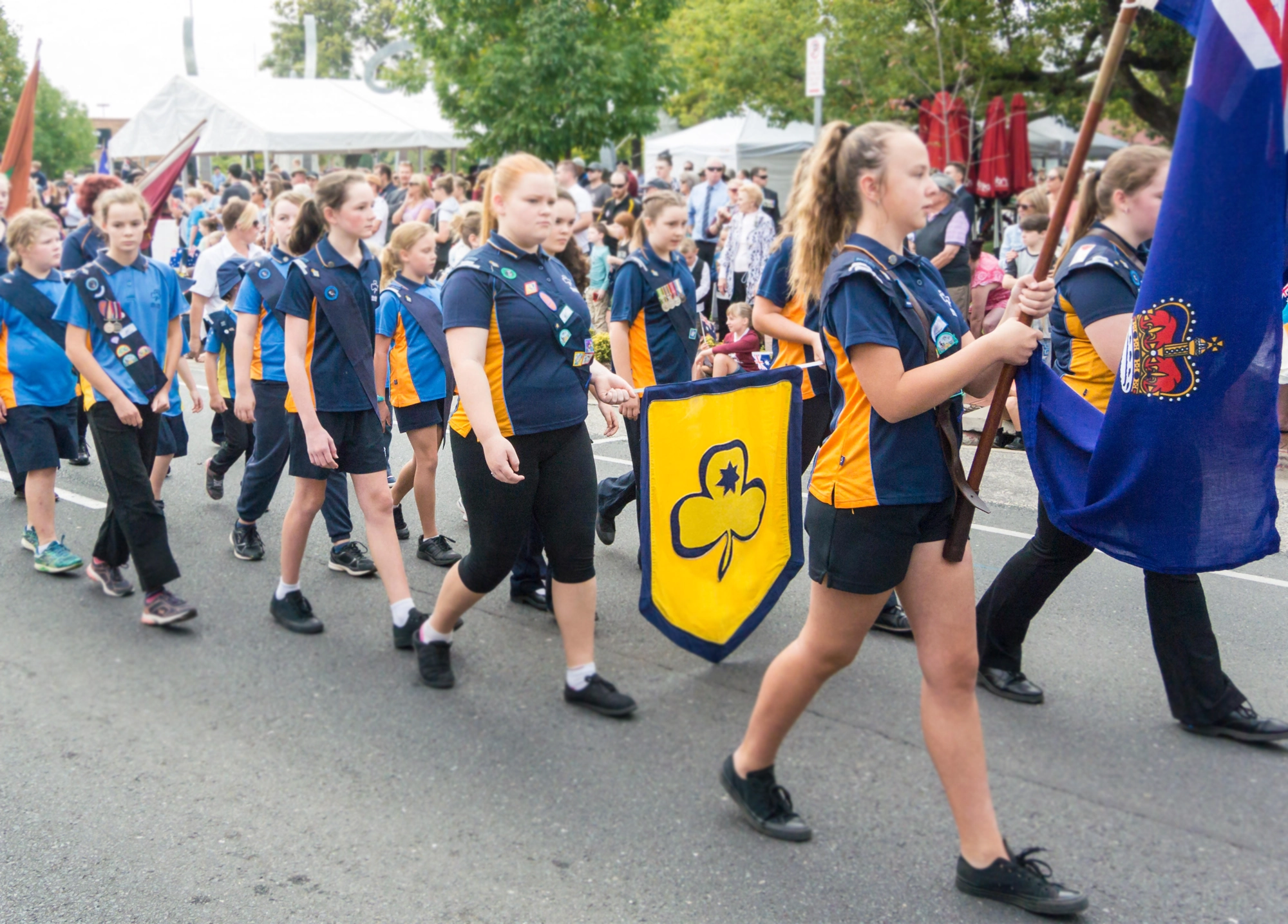 Girl Guides Australia members marching in uniform with badges during a community parade