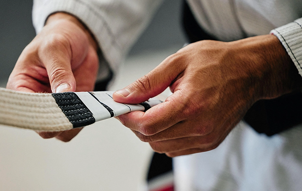 Martial arts student receiving belt ranking during training